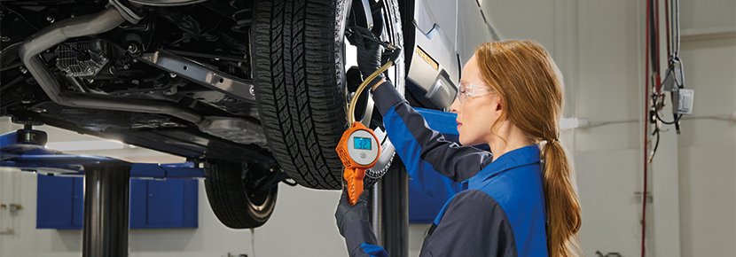 A Subaru technician checking tire pressure. | Open Road Subaru in Union NJ